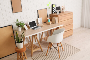 Interior of teenager's room with workplace, drawers and frames
