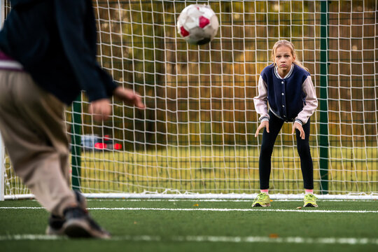 girl soccer player stands at the goal on artificial turf of stadium
