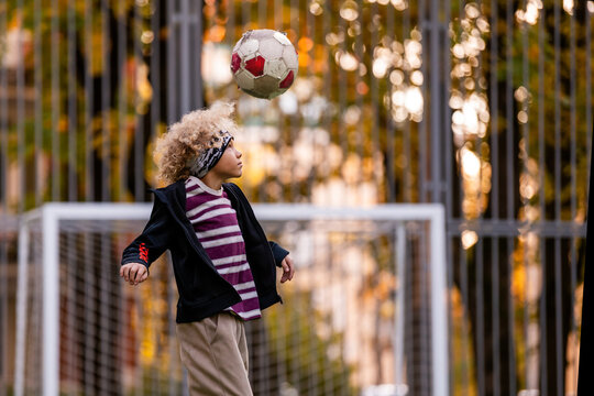soccer boy heads the ball at a street stadium.