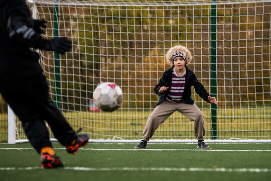 Boy goalkeeper ready to save a ball during a soccer match.