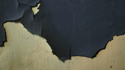 Wall with peeling and damaged black paint surface