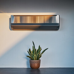 A sleek air conditioning unit mounted on a white wall above a potted plant on a dark wooden table