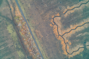 Aerial view of a long military defensive line with trenches cutting through a field showing combat engineering and fortification in Ukraine war