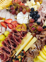 Charcuterie board with cheese, cured meats and fresh fruits