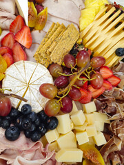 Assortment of cheeses, fruits, and cured meats. Bar delicious platter