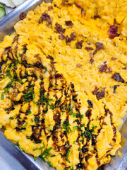 Scrambled eggs with chives bacon and sauce on serving tray