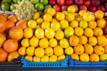 A pile of exotic citrus fruit: lemons, oranges, limes, etc., on a market stall.

