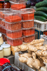 Small boxes with ground spices on a market stall.

