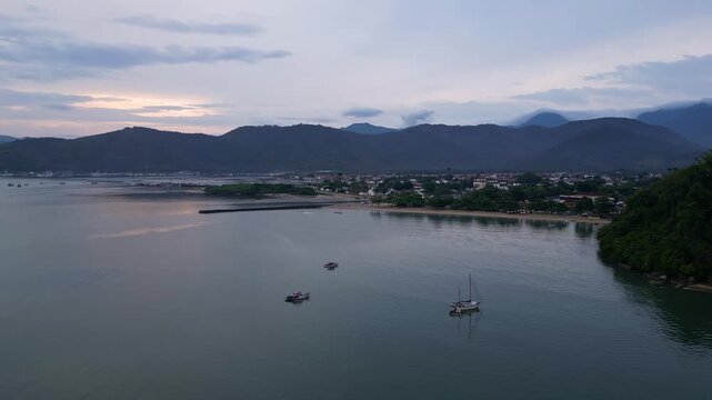Paraty, Brazil: Cinematic time wrap aerial drone footage of Paraty coastal area, an old town town in Rio de Janeiro, Brazil during dramatic sunset with mountain on the Costa Verde in the back