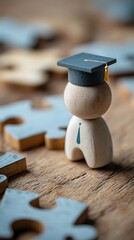 Figurine en bois avec chapeau de dipl&ocirc;m&eacute; entour&eacute;e de pi&egrave;ces de puzzle