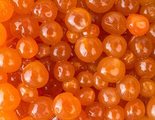 Close-up view of vibrant orange fish roe, a delicacy, with glistening, translucent spheres.