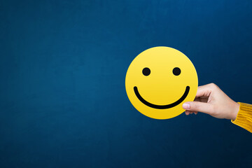 Excellent, service rating, positive feedback and satisfaction. Hand holding smile face emoticon indicating satisfaction level of service users