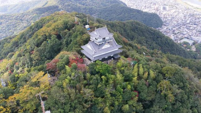 Rear oblique drone aerial close-up of Gifu Castle in autumn daylight, Mount Kinka, Japan　岐阜城