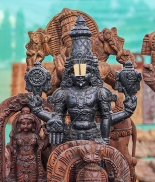 A Divine sculpture of Lord Balaji carved from sacred wood, idol, statue, Srinivasa, Hinduism, intricate, spirituality, Venkateshwara, worship, god, India.