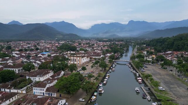 Paraty, Brazil: Aerial orbit drone footage above canal in Paraty, an old town in Rio de Janeiro, Brazil with dramatic mountain of the Costa Verde, the green coast in the evening.