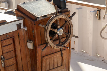 Wooden ship steering wheel and helm on a boat, navigating and guiding direction while sailing on the sea