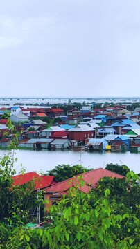 Viewpoint of a flooded fishing village near the Krahom Temple, Cambodia. From the mountain Krahom (Pnom Krom) overlooking the lake Tonlesap. Houses are built on high stilts. Rainy season. 4К