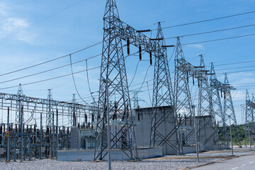 High voltage electric substation with power transmission lines and steel towers under blue sky....