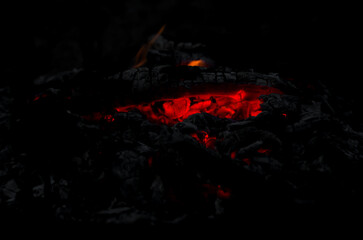 Glowing Embers in Cold Night Ashes Create Warm Light and Subtle Fire Spots in a Fire Pit