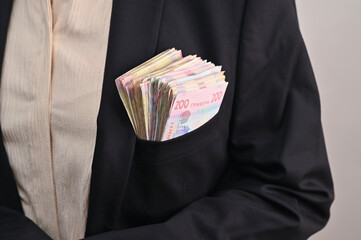 There is a stack of banknotes in the man's jacket pocket. Ukrainian hryvnia in your pocket. Cash money.