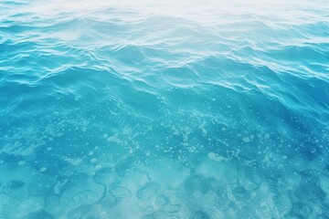 Obraz premium Gentle waves ripple across a crystal clear turquoise water surface, dotted with air bubbles, evoking a sense of tranquility and serenity