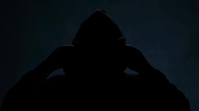 Mysterious hooded figure reveals identity in dramatic shadowy sequence