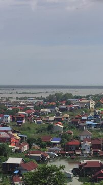Viewpoint of a flooded fishing village near the Krahom Temple, Cambodia. From the mountain Krahom (Pnom Krom) overlooking the lake Tonlesap. Houses are built on high stilts. Rainy season. 4К