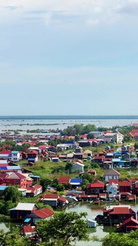 Viewpoint of a flooded fishing village near the Krahom Temple, Cambodia. From the mountain Krahom (Pnom Krom) overlooking the lake Tonlesap. Houses are built on high stilts. Rainy season. 4К