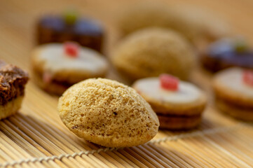Various kinds of tasty Christmas chocolate, nuts and filled cookies on japanese wooden mat