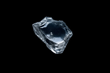 angular piece of clear glass, rough, faceted surfaces and sharp edges, isolated against black, studio photograph, symbolizes raw material, natural formation, or broken structure, sharp detail