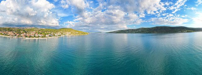 Wybrzeże Chorwacji w klimatycznym momencie pięknych chmur w okolicach Trogiru, wioska z lotu ptaka w lecie.