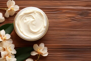 Obraz premium Moisturizing cream in a jar surrounded by flowers on a wooden table, promoting natural skincare and beauty products