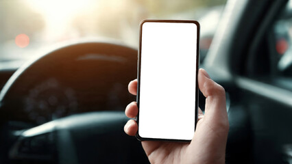 Hand Holding a Smartphone with Blank Screen in a Car Interior during a Sunny Day with Blurred Background