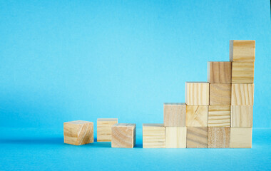 business concept, wooden blocks as a pyramid staircase on blue background. Success, innovation,growth, success, development or top ranking concept
