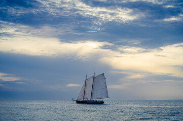 Bateau à voile 2 mats voguant face à l'horizon sous un ciel voilé de fin d'après-midi à Key West, Floride, USA © Pascal