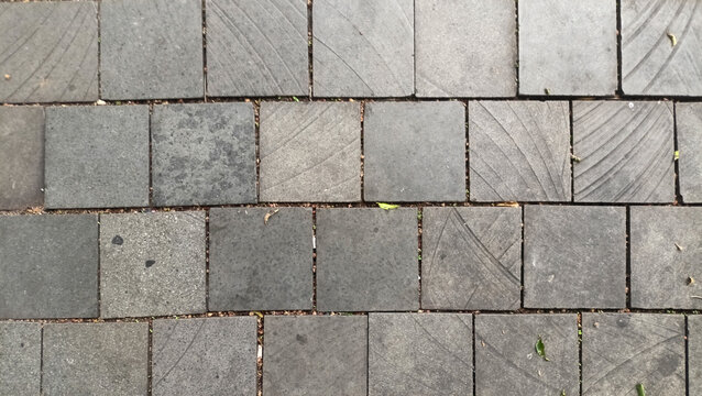 Texture of Andesite natural stone floor tiles in grey with natural diagonal line patterns neatly arranged in an outdoor area.