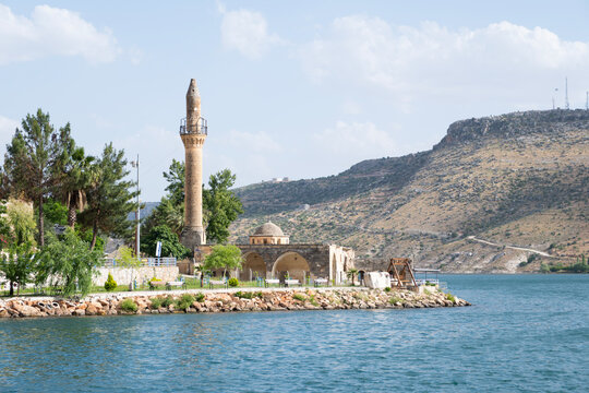 Old halfeti grand mosque minaret standing partially submerged by the blue waters of the euphrates river, showcasing ancient architecture and cultural heritage in turkey