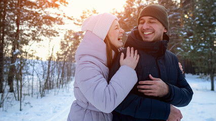Laughter Shared During Cold Outdoor Adventure, Pair Chuckling Amidst Snowcovered Trees During Festive Season, Enthusiastic Duo Enjoying Frosty Walk Through Pine Forest With Cheerful Expressions
