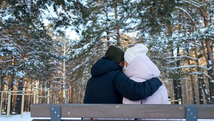 Warm Winter Moments Shared, Intimate Scene With Snowy Surroundings, Two Individuals Enjoying Cozy Winter Time Outdoors, Romantic Pair Relaxing On Bench Amidst Snow Covered Pine Trees