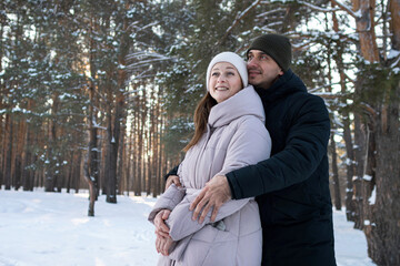 Couple Sharing Loving Winter Kiss, Two Affectionately Embracing Individuals In Cold Winter Forest Setting, Romantic Partners Sharing Gentle Kiss Amid Snowcovered Trees And Bright Sunlight