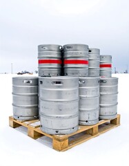 Metal beer kegs on a pallet in snow