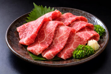 Exquisite Japanese raw sliced beef sashimi with garnish presenting refined cuisine luxury dining delicate texture and traditional culinary artistry