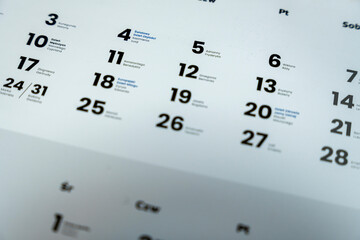 Close-up of a modern calendar showing weekdays and dates. Includes significant days marked in blue, ideal for event planning, organizing, or scheduling purposes.