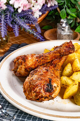 Baked chicken drumsticks with potatoes.