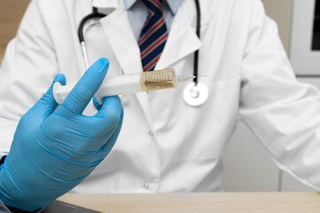 The doctor holds a syringe with a needle in his hand.  