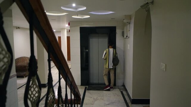 Attractive happy man arriving at hotel and going to the reception lobby from elevator to check in, Banswara, Rajasthan, India.