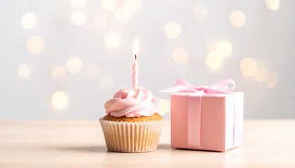 Delightful pink birthday cupcake with a glowing candle and a charming gift box, perfect for celebrating special moments and joyous occasions and making wishes