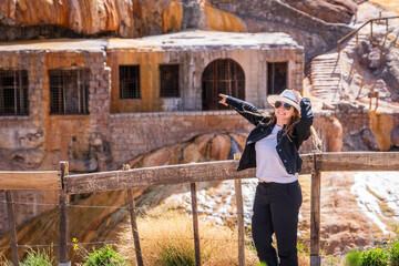 Turista feliz disfrutando del Puente del Inca y señalando hacia las ruinas, en la mítica ruta 7 de la provincia de Mendoza  © Javier