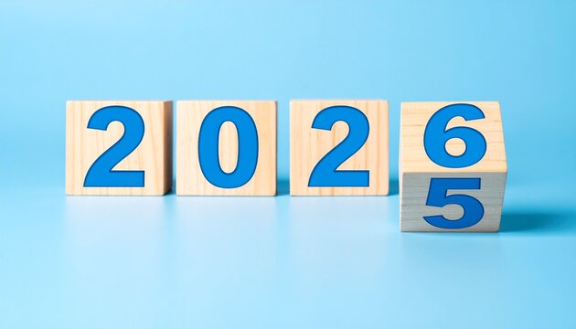 Wooden blocks showing transition from 2025 to 2026 on light blue background. - Powered by Adobe