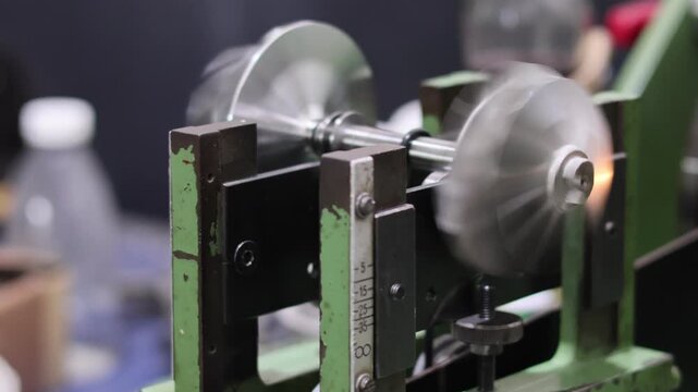 Turbocharger balancing machine in operation. Dynamic balancing of metal turbine wheel and impeller shaft on industrial precision equipment. Professional turbo repair service.